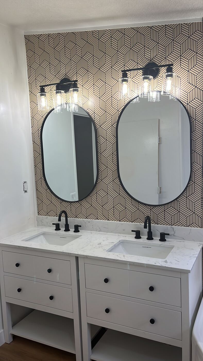 Double vanity bathroom remodel with oval mirrors and matte black fixtures