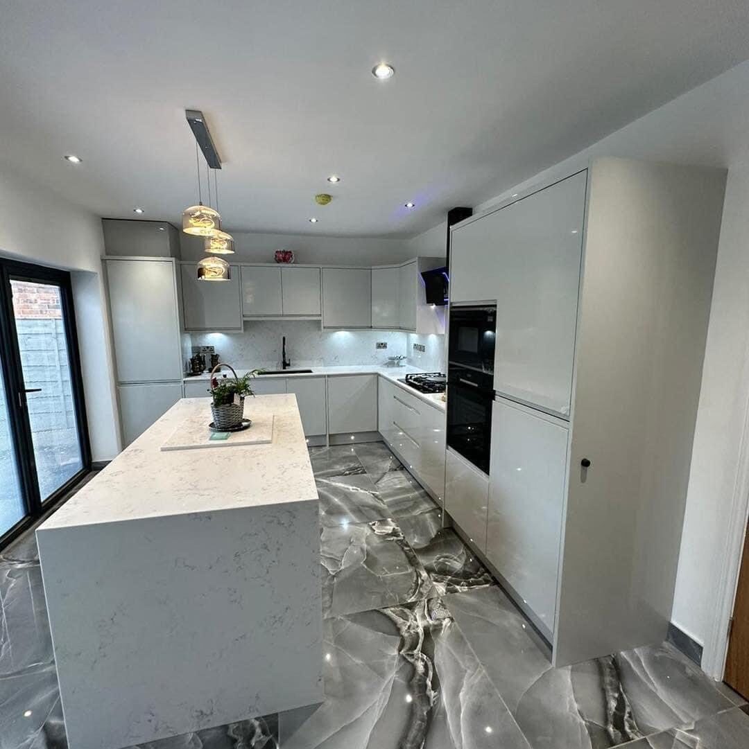 High-gloss white kitchen renovation with dramatic marbled porcelain floor