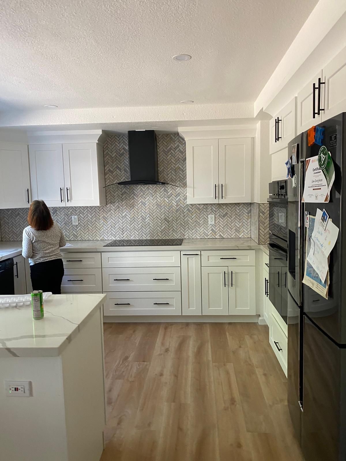 White shaker kitchen renovation with herringbone tile backsplash