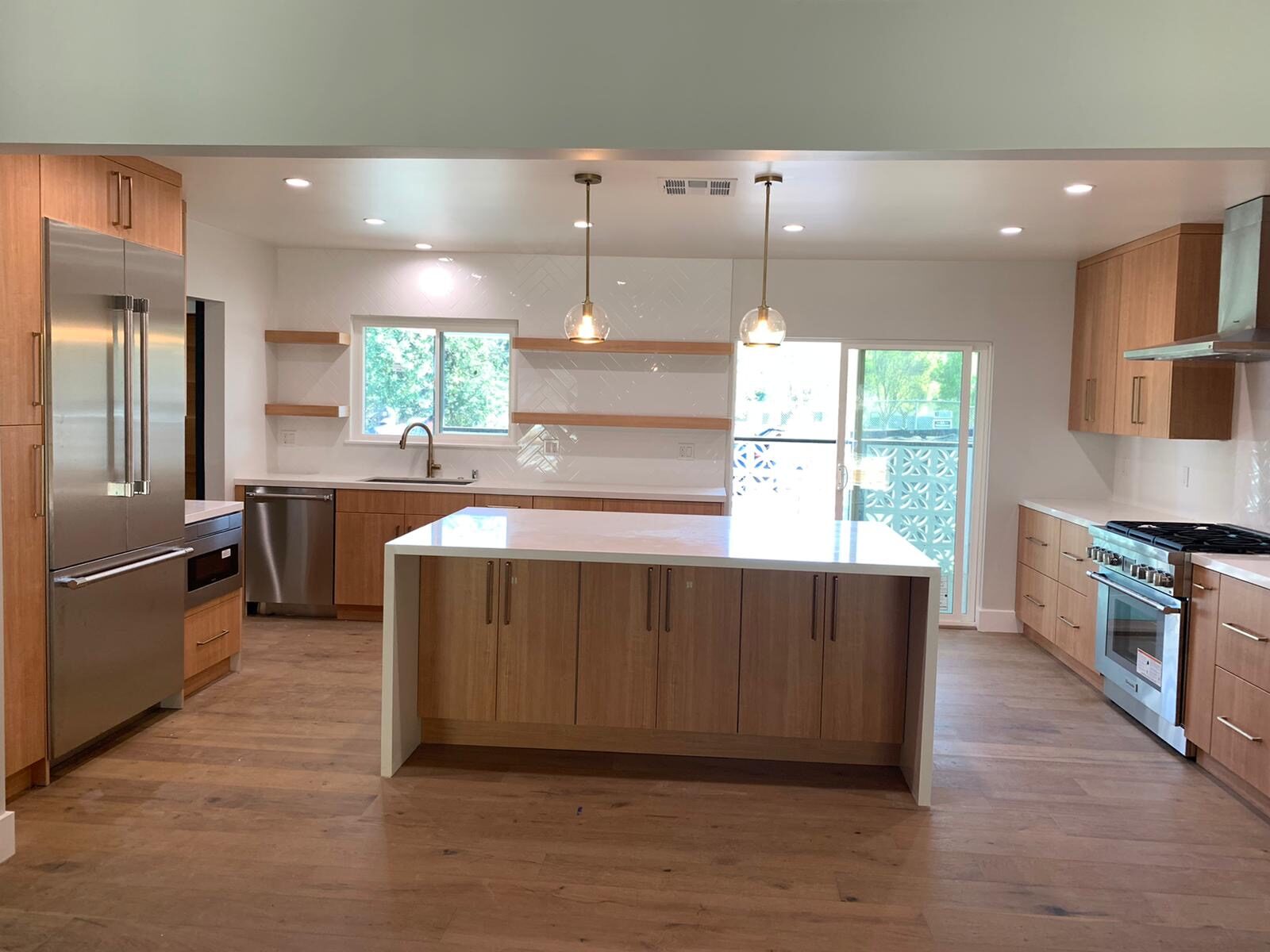 Modern kitchen renovation with open wood shelving and herringbone tile