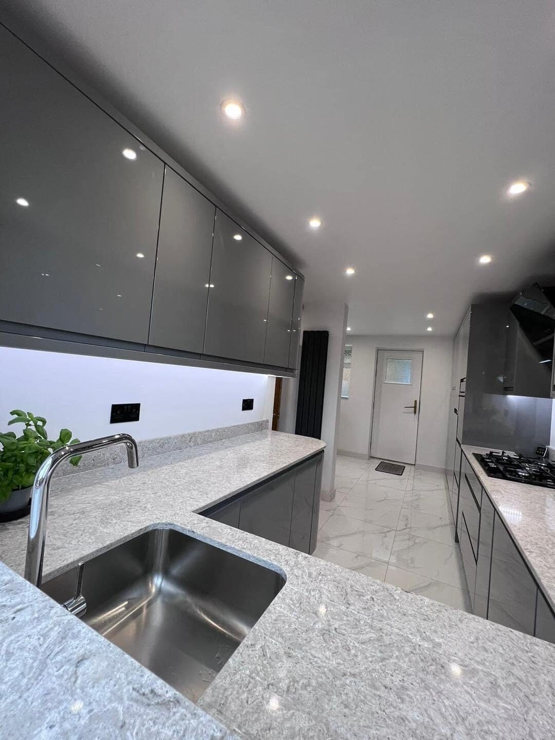 Gray high-gloss kitchen renovation with quartz countertops