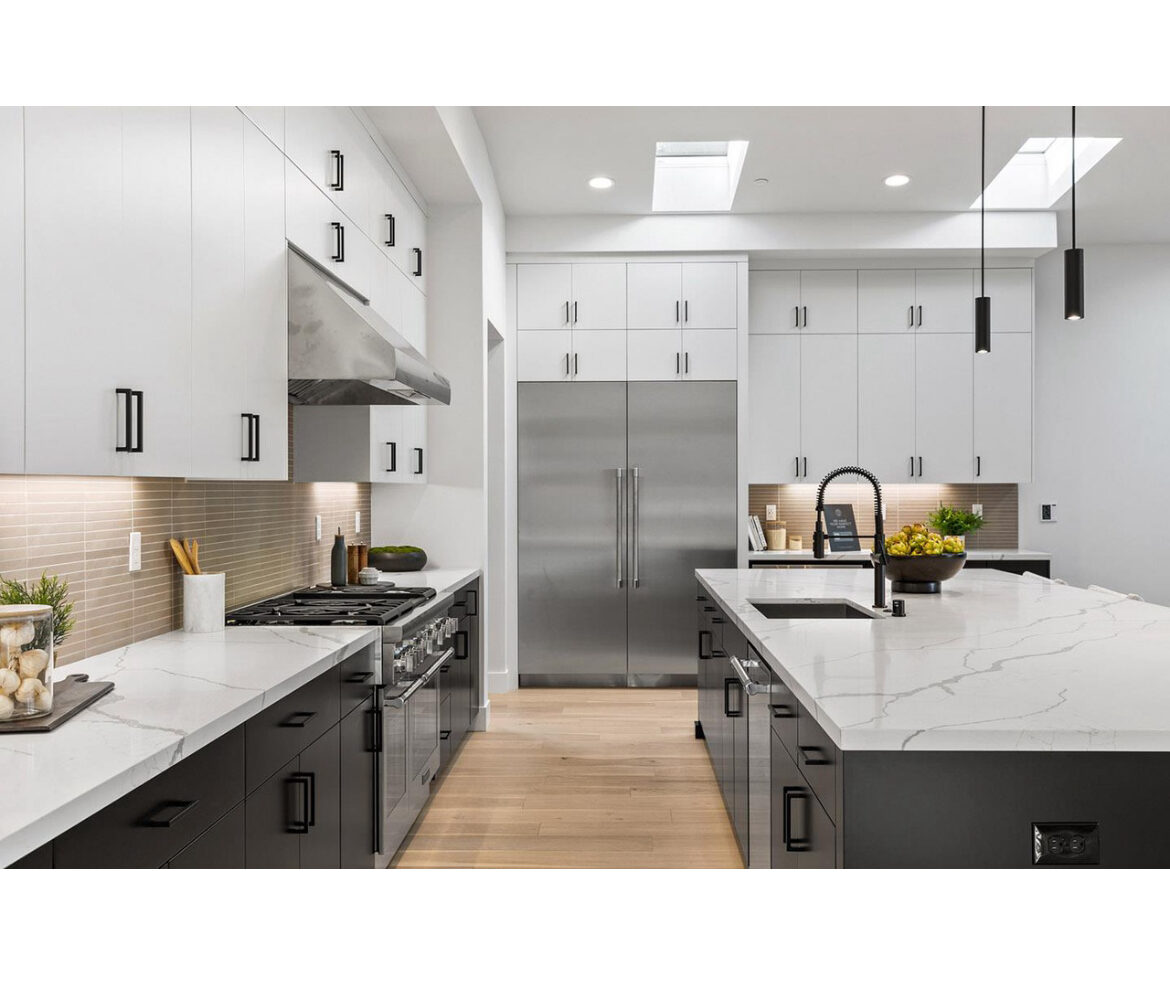 Black and white kitchen renovation with integrated stainless refrigerator wall
