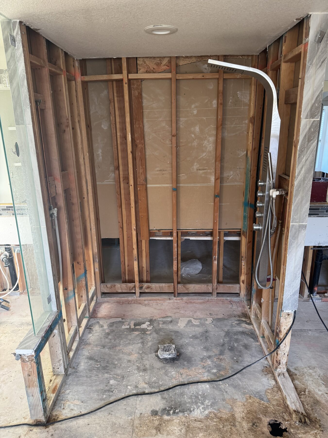 Shower stall framed down to studs with plumbing rough-in during renovation